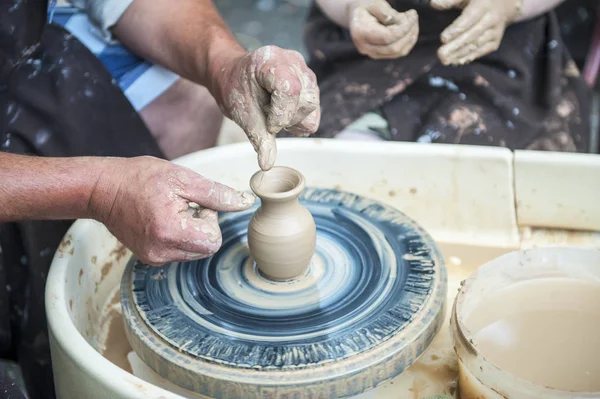 De pottenbakker maakt aardewerk schotels op pottenbakkerswiel. — Stockfoto