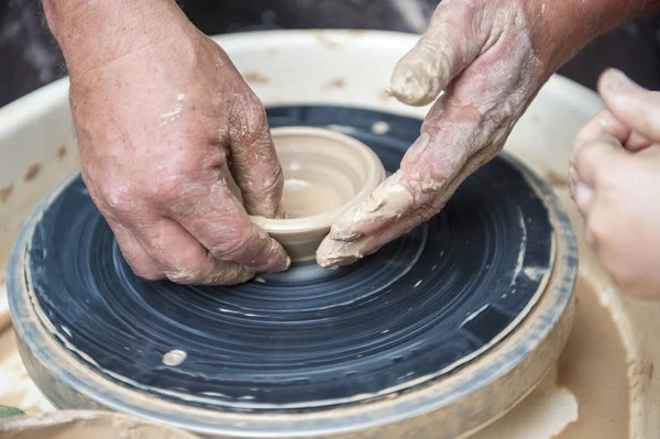 De pottenbakker maakt aardewerk schotels op pottenbakkerswiel. — Stockfoto