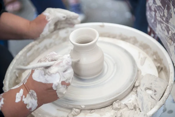 De pottenbakker maakt aardewerk schotels op pottenbakkerswiel. — Stockfoto