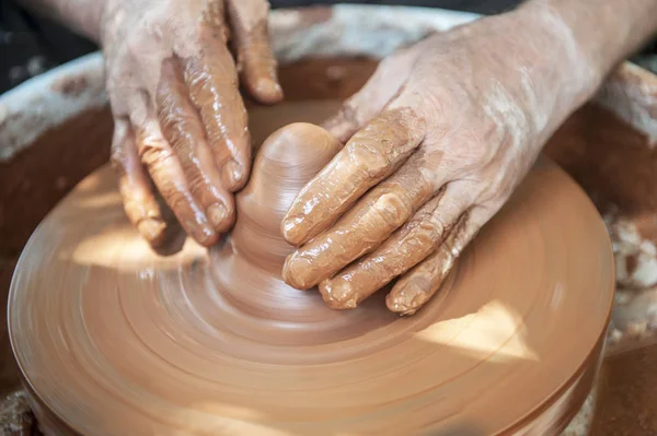 De pottenbakker maakt aardewerk schotels op pottenbakkerswiel. — Stockfoto