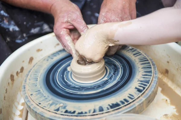 De pottenbakker maakt aardewerk schotels op pottenbakkerswiel. — Stockfoto