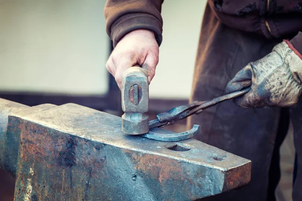 Fabbro lavorazione del metallo con martello sull'incudine — Foto Stock