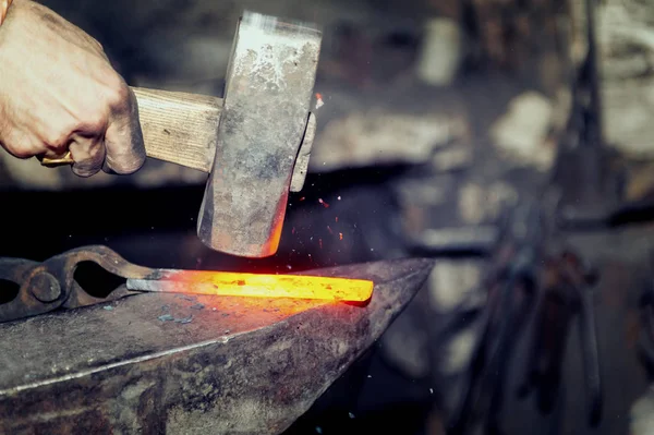 Fabbro lavorazione del metallo con martello sull'incudine — Foto Stock