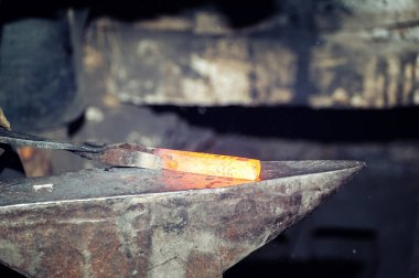 Demirci demir ocağında çekiçle çalışan bir demirci.
