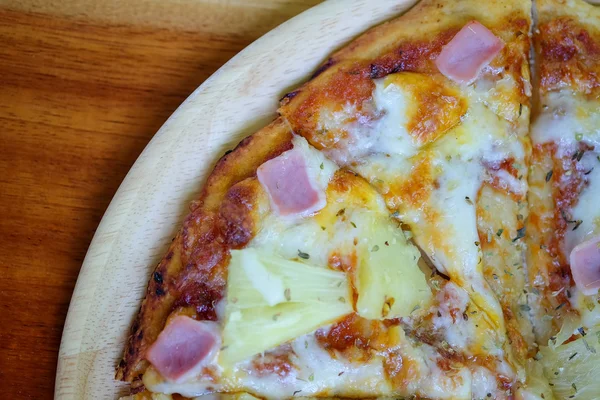 Pizza hawaiana en plato de madera lugar en mesa de madera . — Foto de Stock