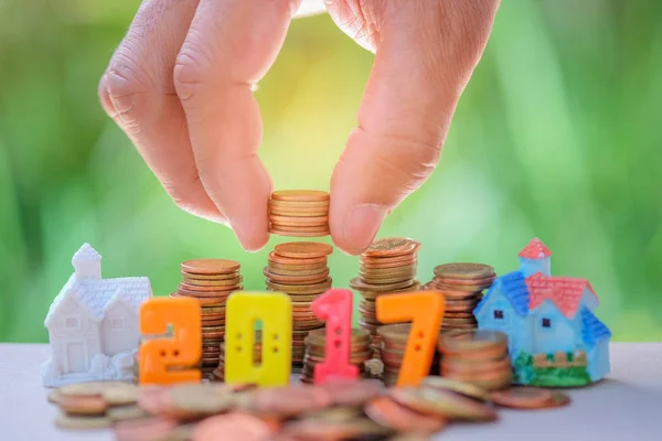 2017 número de texto con monedas.coins a mano puesto a la casa modelo . —  Fotos de Stock