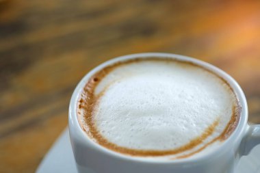 Geç kahve beyaz kupa closeup ahşap üzerinde.