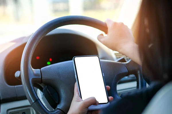 Mujer usando un smartphone mientras conduce . — Foto de Stock
