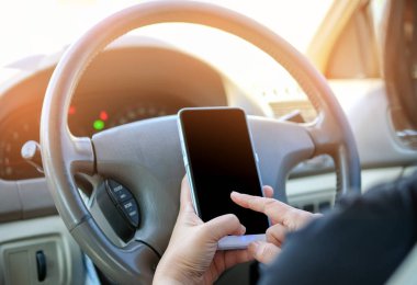 Sürüş sırasında bir akıllı telefon kullanan kadın.