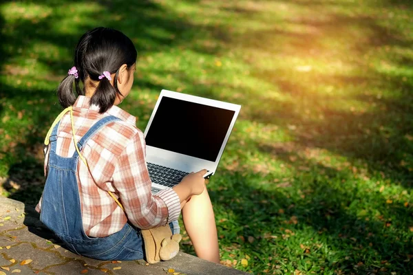 Dizüstü bilgisayar kullanan arkasında oturan kız.