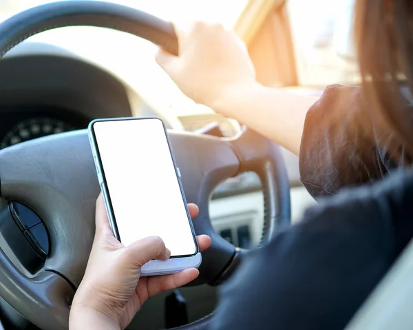 Mujer usando un smartphone mientras conduce . — Foto de Stock
