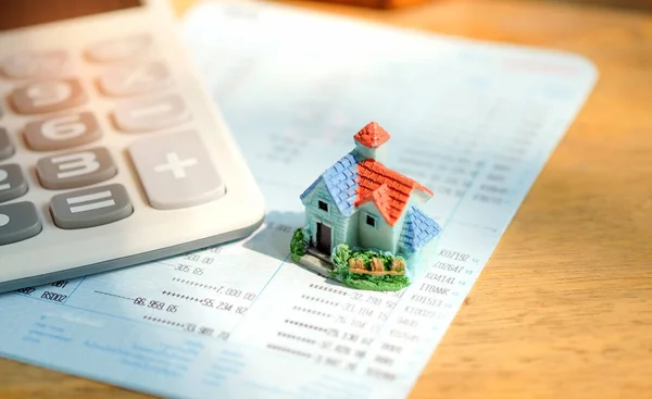 Modèle de maison avec calculatrice sur la banque de livre . — Photo