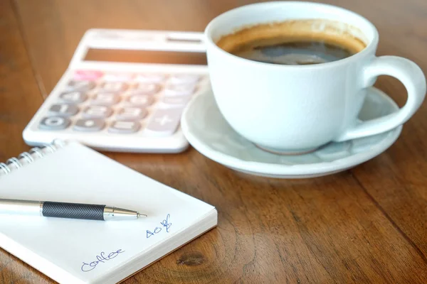 Concepto, taza de café y portátil con calculadora en madera . — Foto de Stock