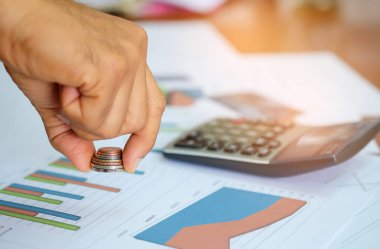 Erkekler ellerinde paralar maliyet analizi hesap makinesini kullanarak.