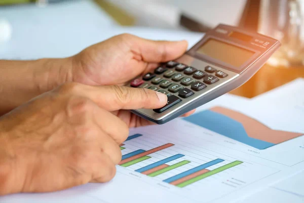 Men are using a calculator to analyze income data. — Stock Photo, Image