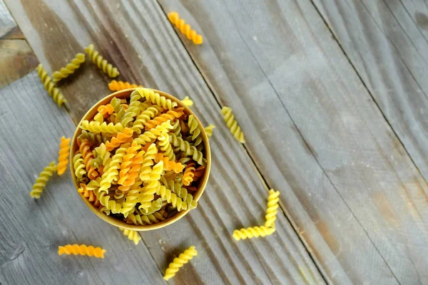 Spiral pasta in wooden cup. — Stock Photo, Image