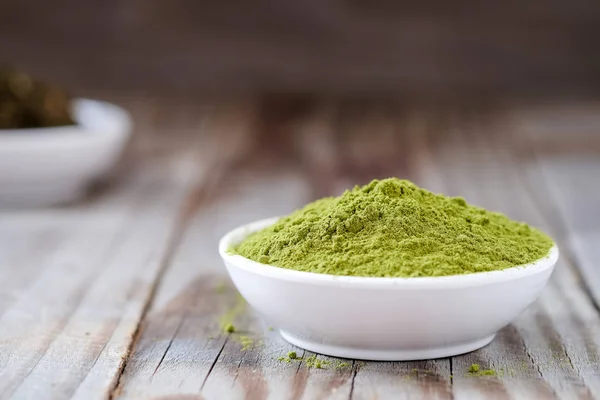 Té verde en polvo con té seco en taza blanca . — Foto de Stock