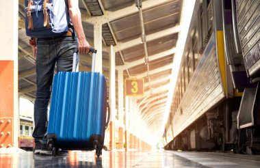 Asya turizm tra üzerinde mavi bir çanta tekerlekli sürükleme