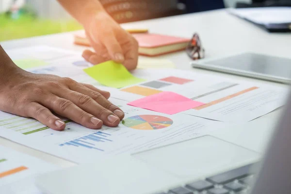 Office worker analyzing graph,other hand catches a flip chart. — Stock Photo, Image