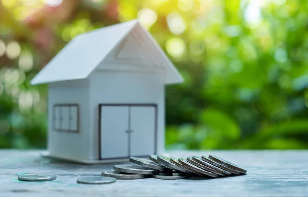 House concepts,Coin and model house on wooden floor. — Stock Photo, Image