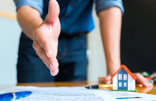 Ev satış elemanı için sallar uzanır eller, kalem ve model ev h