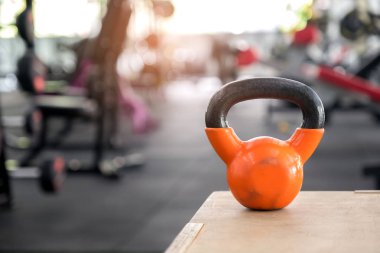 Turuncu kettlebell üzerinde tahta bir sandık koymak.