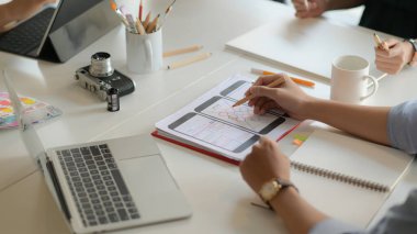 Modern ofis odasında dijital tablet kullanarak akıllı telefon uygulama projesi üzerinde çalışan genç UX tasarımcı ekibinin kırpılmış görüntüsü.