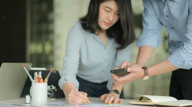 Profesyonel tasarımcılardan oluşan bir ekip akıllı telefon ve dizüstü bilgisayarlarla uygulama tasarlamak için çalışıyor..