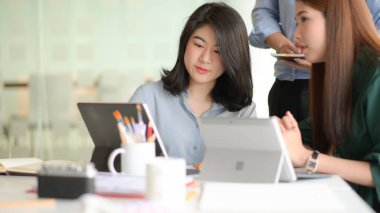 Profesyonel tasarımcılardan oluşan bir ekip akıllı telefon ve dizüstü bilgisayarlarla uygulama tasarlamak için çalışıyor..