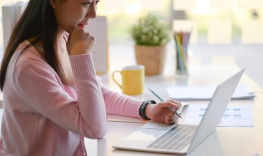 Genç kadınların modern kişisel ofiste çekilmiş fotoğrafları dizüstü bilgisayar kullanıyor..