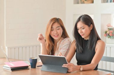 İki genç kız öğrenci yaz tatilinde evde çalışmak için dizüstü bilgisayar kullanıyor, evde çalışıyor, evde çalışıyor..