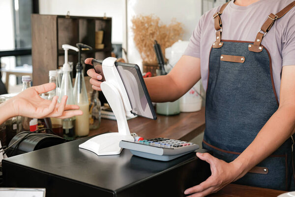 Barista is using the screen to receive orders from customers who are pointing to order coffee.