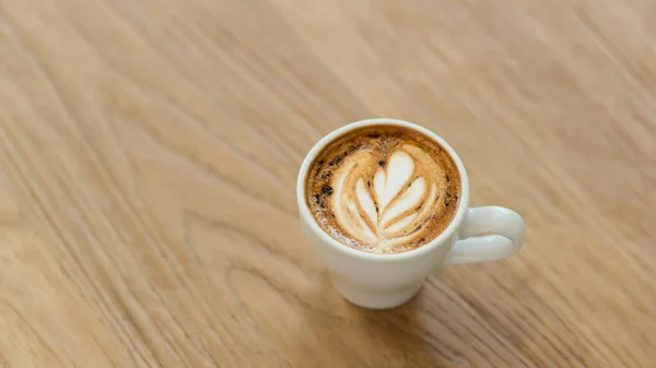 Kawa Kształcie Serca Latte Ułożone Białym Kubku Pięknej Wzorzystej Drewnianej — Zdjęcie stockowe