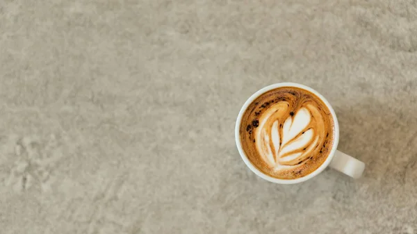 コンクリートの床に白いガラスに積層ハート型のコーヒーラテ — ストック写真