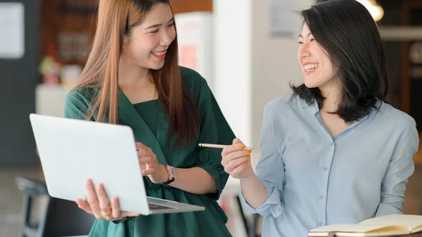 若いビジネス女性は良い感情を持つ現代のオフィスで一緒にプロジェクトを議論するためにラップトップを使用します — ストック写真