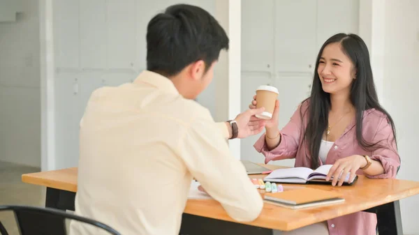 試験準備のための本を読むことによって強調しながら 女性にコーヒーを与える男性のショット — ストック写真