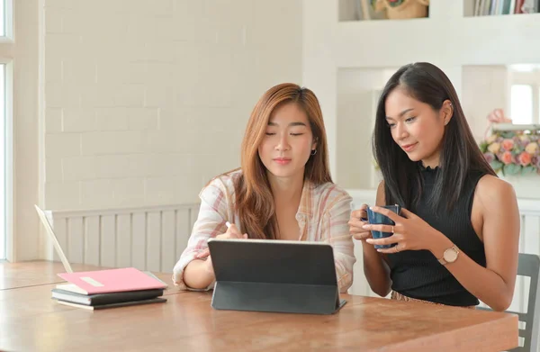 コーヒーを飲んでいる2人の若い女性学生は 夏学期に自宅でオンラインで勉強するためにラップトップを使用しています 自宅で仕事 自宅から仕事 — ストック写真