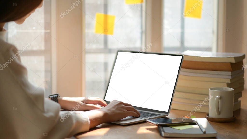 Young business women are using blank screen laptop with office equipment in modern office.