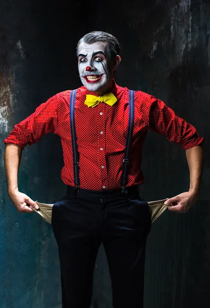 Verschrikkelijke clown en Halloween thema: Crazy rode clown in een shirt met bretels tegen een donkere achtergrond — Stockfoto