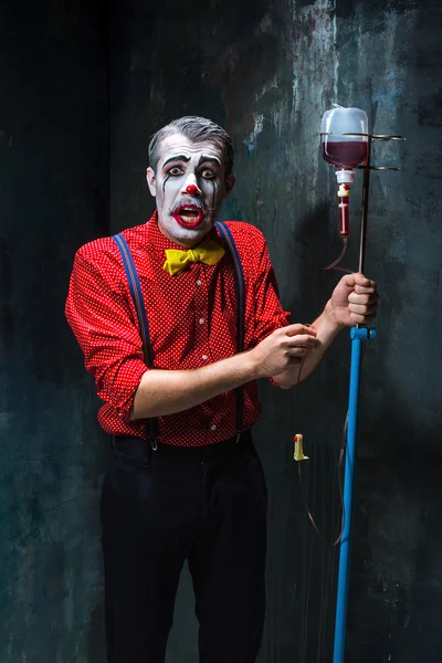 Il clown spaventoso e gocciolare con il sangue su sfondo dack. Concetto Halloween — Foto Stock