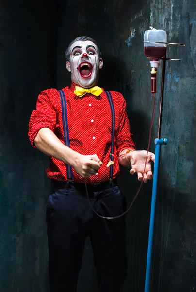 Läskig clown och dropp med blod på däck bakgrund. Halloween-konceptet — Stockfoto