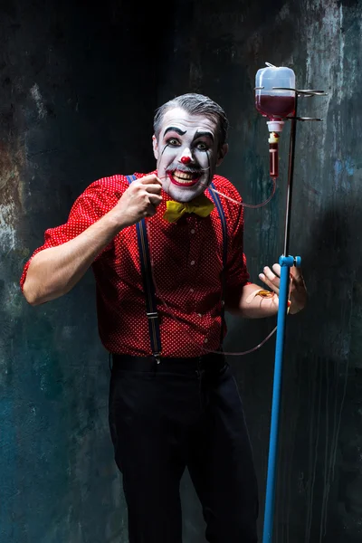 Hrůzostrašný klaun a odkapávací s krví na pozadí Dacku. Koncept Halloween — Stock fotografie