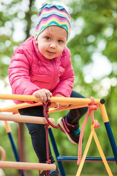 A menina brincando no playground ao ar livre — Fotografia de Stock