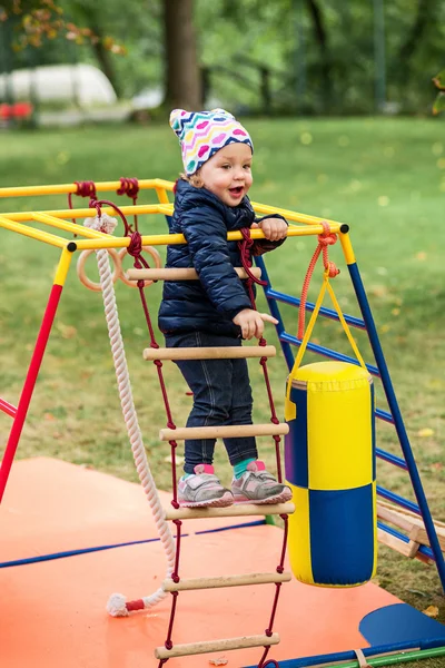 A menina brincando no playground ao ar livre — Fotografia de Stock
