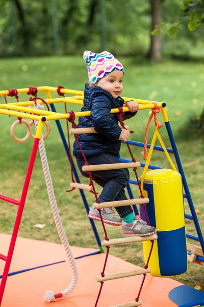 A menina brincando no playground ao ar livre — Fotografia de Stock