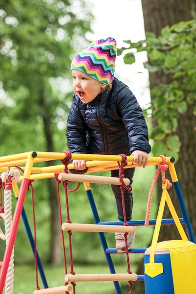 A menina brincando no playground ao ar livre — Fotografia de Stock