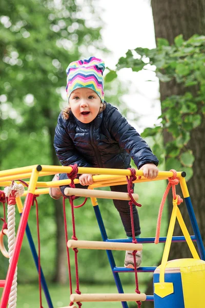 A menina brincando no playground ao ar livre — Fotografia de Stock