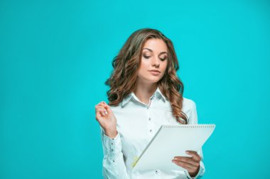 Gülümseyen genç iş kadın kalem ve tablet için mavi arka plan ile ilgili notlar