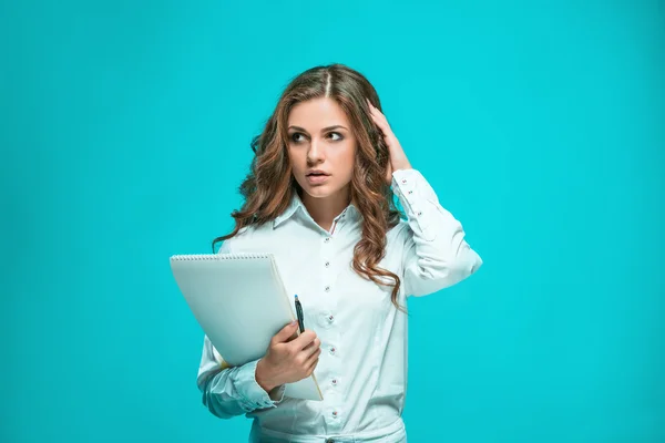 La giovane donna d'affari premurosa con penna e tablet per appunti su sfondo blu — Foto Stock