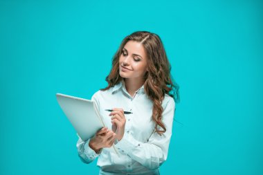 Gülümseyen genç iş kadın kalem ve tablet için mavi arka plan ile ilgili notlar
